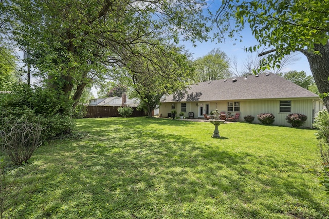 3660 S Ferguson Ave, Springfield, MO 65807 - rear view of house with a lawn, fence, and a shingled roof