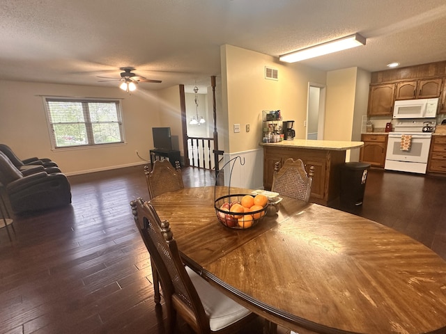 dining area featuring visible vents, a ceiling fan, a textured ceiling, and dark wood-type flooring