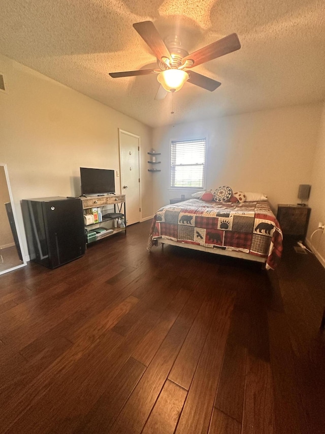 bedroom with a ceiling fan, a textured ceiling, and hardwood / wood-style floors