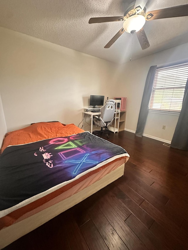 bedroom with wood-type flooring, a textured ceiling, ceiling fan, and baseboards