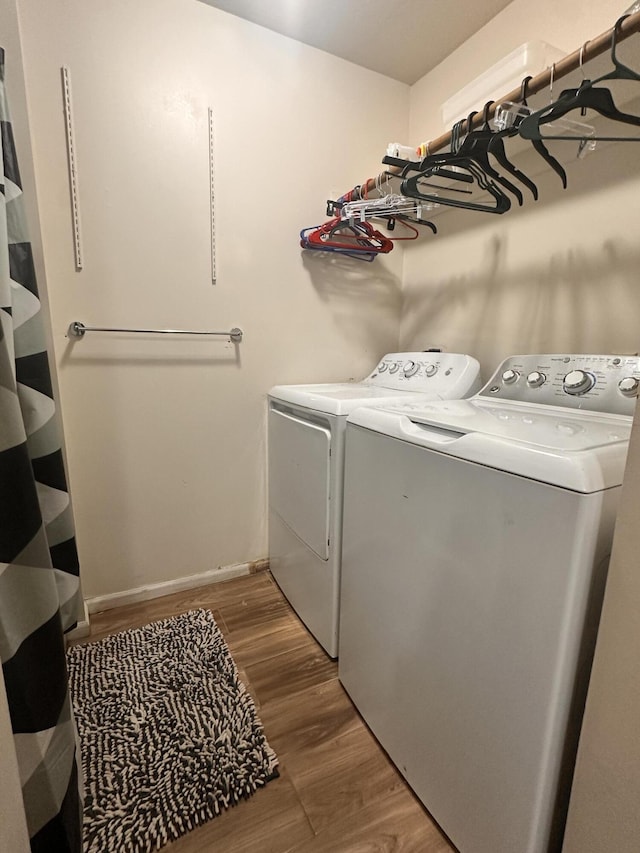 laundry room featuring washer and dryer, laundry area, baseboards, and wood finished floors