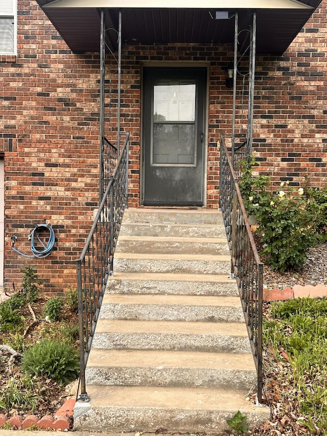entrance to property featuring brick siding