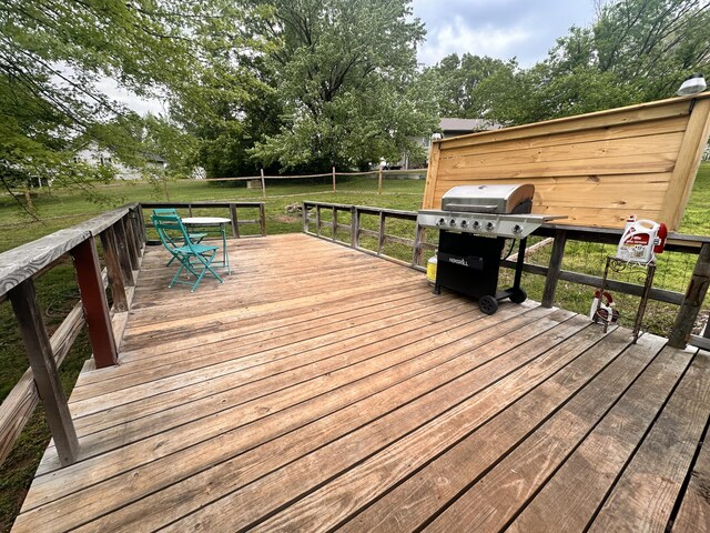 wooden deck featuring a yard, grilling area, and outdoor dining space