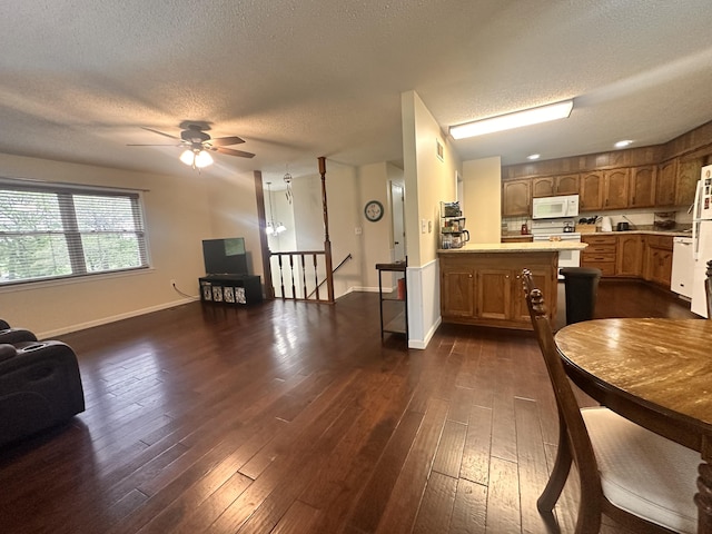 interior space featuring baseboards, ceiling fan, dark wood-style flooring, and a textured ceiling