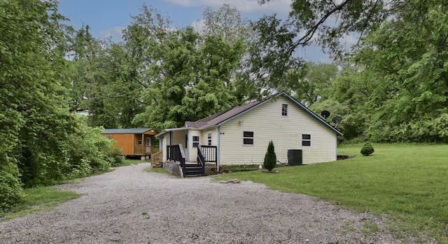 418 S 5th St, Branson, MO 65616 - view of home's exterior featuring a lawn, driveway, cooling unit, an outbuilding, and a deck