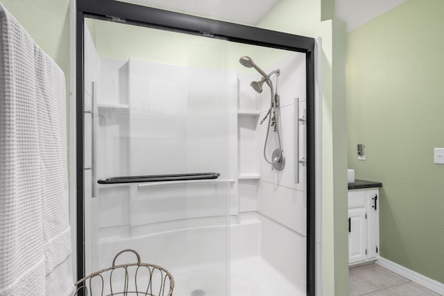full bathroom featuring baseboards, tile patterned flooring, and a shower stall