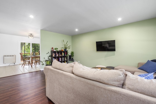 living area with recessed lighting, heating unit, and wood finished floors