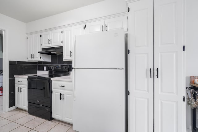 kitchen featuring light tile patterned flooring, light countertops, freestanding refrigerator, black / electric stove, and under cabinet range hood