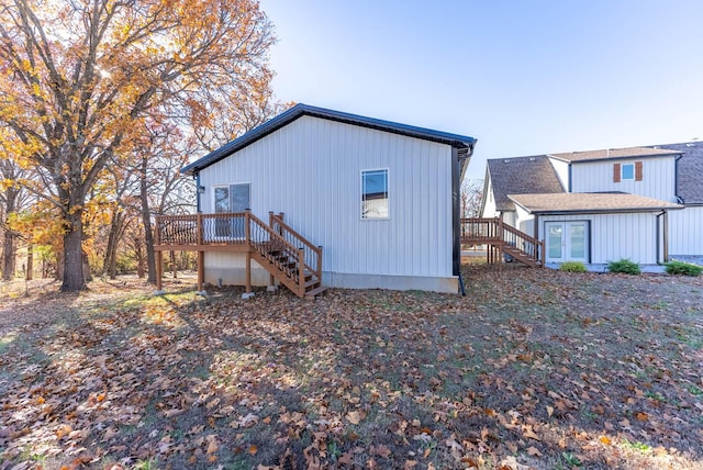 back of house featuring stairs, a wooden deck, and french doors