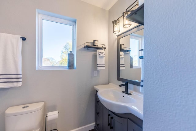 half bath featuring vanity and toilet