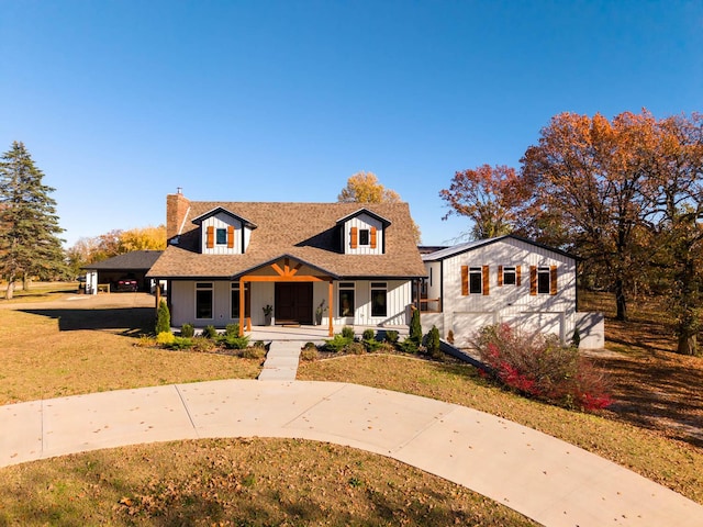 bungalow-style house with a porch, a chimney, a shingled roof, and a front lawn