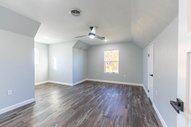 additional living space with a ceiling fan, visible vents, dark wood finished floors, baseboards, and lofted ceiling