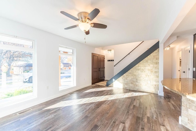 entryway with visible vents, wood finished floors, baseboards, stairway, and a ceiling fan