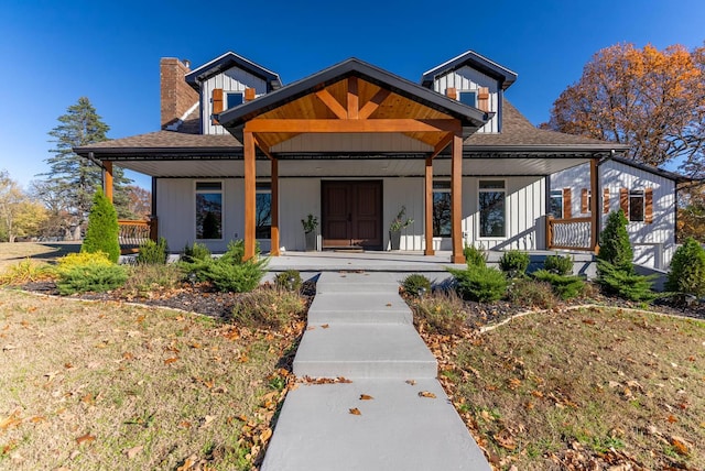 bungalow with a porch, a chimney, and roof with shingles