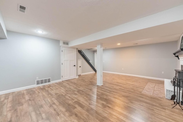 finished basement featuring visible vents and light wood-style floors