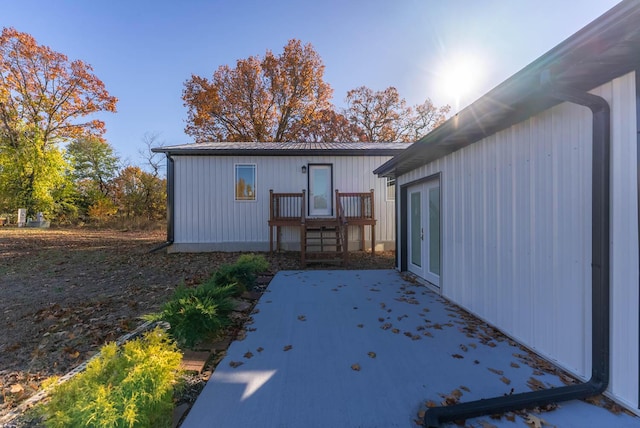 rear view of property with a patio area, french doors, and metal roof