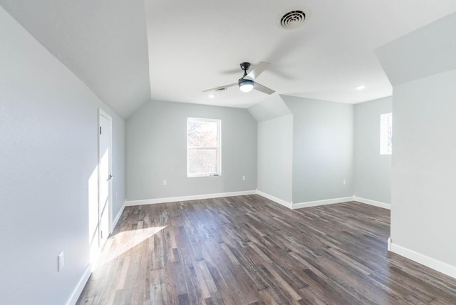 additional living space featuring ceiling fan, baseboards, vaulted ceiling, visible vents, and dark wood-style floors