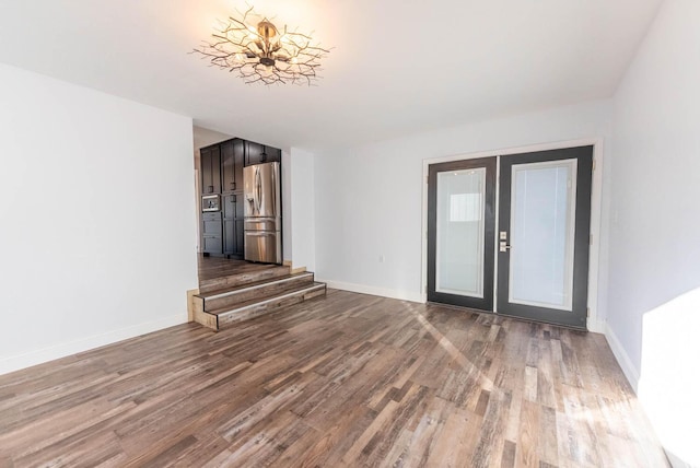 interior space with french doors, baseboards, and wood finished floors
