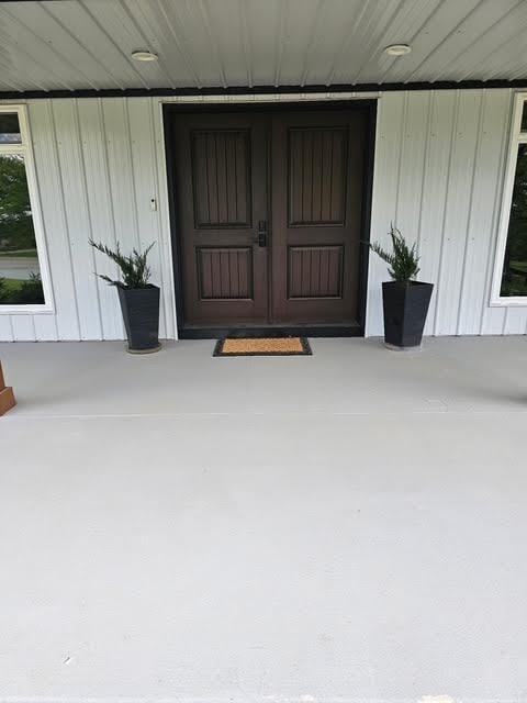 410 White Oak Dr, El Dorado Springs, MO 64744 - view of exterior entry with a porch and board and batten siding