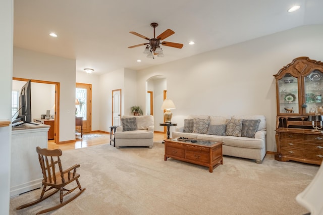 living area with arched walkways, a ceiling fan, recessed lighting, and light carpet