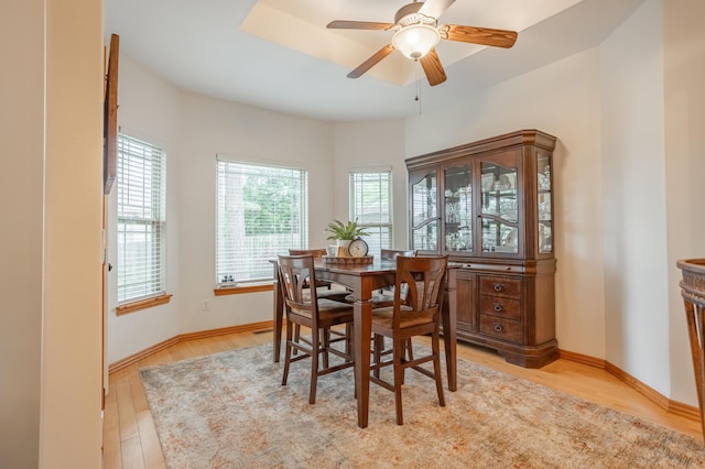 dining room with baseboards, light wood finished floors, and ceiling fan