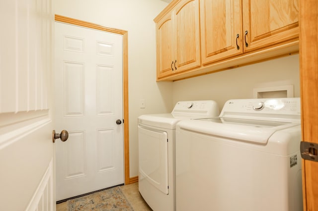 washroom featuring independent washer and dryer, light tile patterned floors, and cabinet space