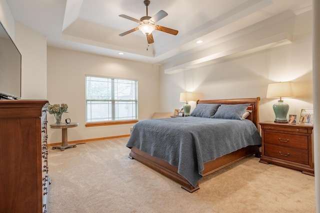 bedroom with ceiling fan, light colored carpet, a raised ceiling, recessed lighting, and baseboards