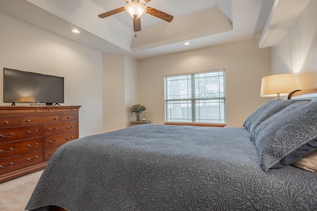 bedroom featuring light colored carpet, recessed lighting, a raised ceiling, and a ceiling fan