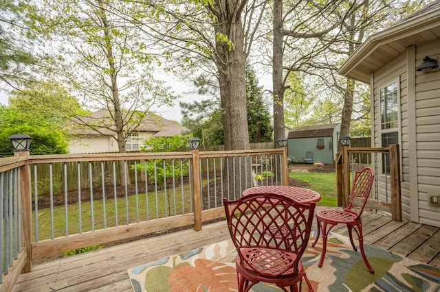 wooden deck featuring an outdoor structure, a fenced backyard, a yard, and a storage shed