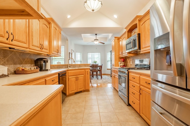 kitchen with a ceiling fan, light tile patterned flooring, light countertops, a sink, and stainless steel appliances