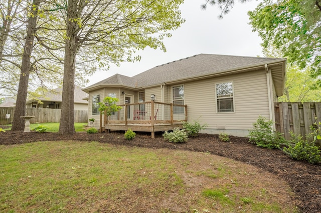 back of property featuring a yard, fence, and a wooden deck