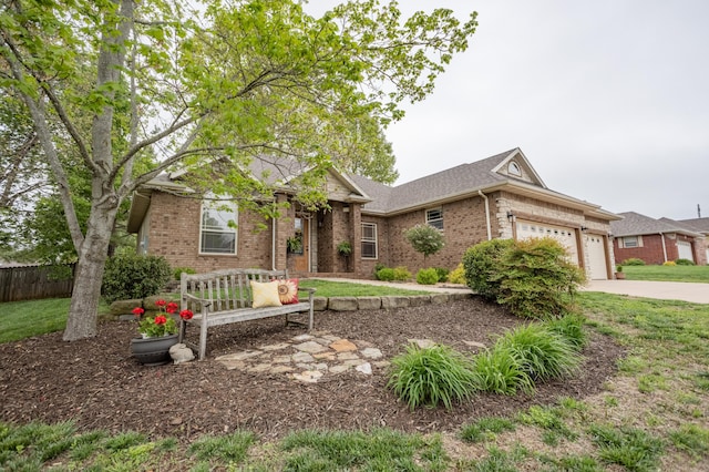 view of front of property featuring fence, a front yard, brick siding, concrete driveway, and an attached garage