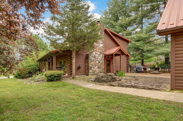 121 Waverly St, Hollister, MO 65672 - view of home's exterior featuring a lawn, a patio, a chimney, and log siding