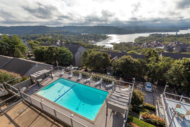 community pool with fence and a water view