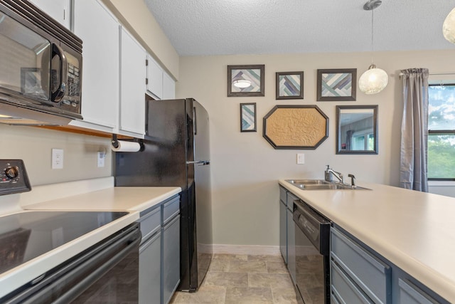 kitchen featuring light countertops, white cabinets, a sink, and black appliances