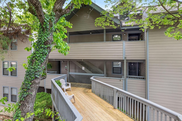 rear view of property with stairway and a balcony