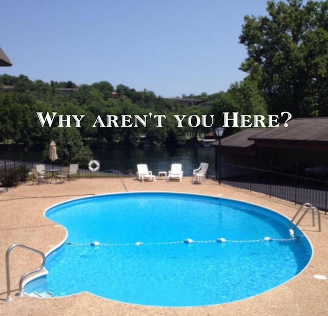 pool with fence and a patio area
