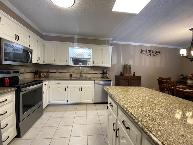 kitchen featuring a sink, white cabinetry, appliances with stainless steel finishes, and ornamental molding