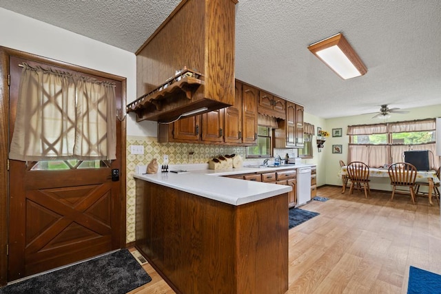 kitchen featuring light wood-style floors, ceiling fan, light countertops, a textured ceiling, and dishwasher