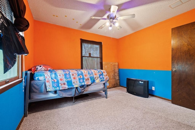 carpeted bedroom with visible vents, baseboards, and ceiling fan
