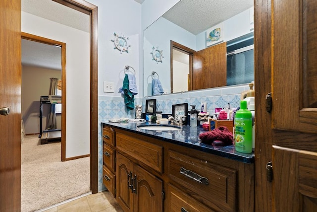 bathroom with backsplash, a textured ceiling, tile patterned flooring, and vanity