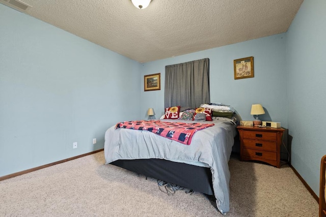 bedroom featuring carpet floors, a textured ceiling, visible vents, and baseboards