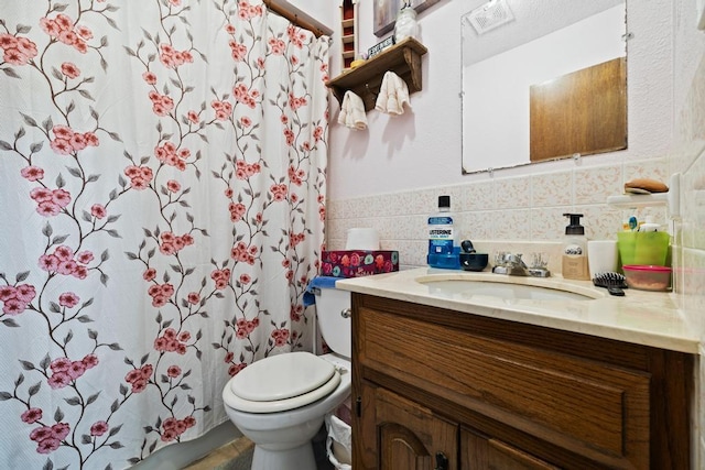 full bath featuring vanity, wainscoting, toilet, tile walls, and a shower with curtain