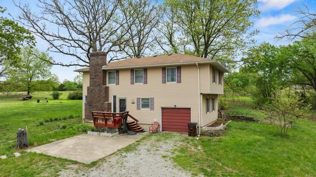 back of house featuring a lawn, a wooden deck, driveway, and a chimney