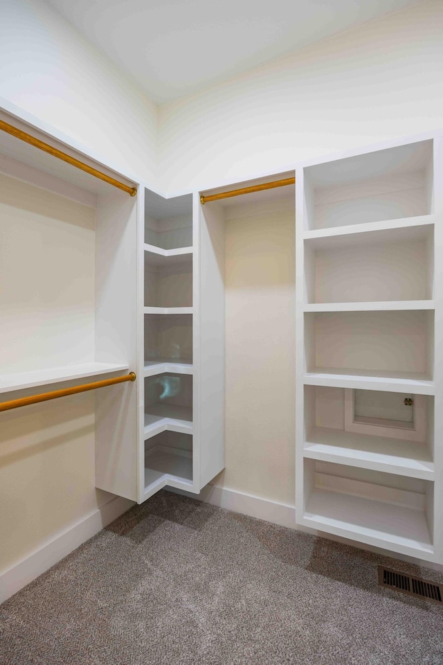 walk in closet featuring visible vents and dark colored carpet
