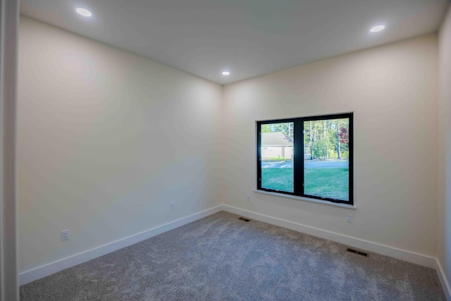 carpeted spare room featuring recessed lighting, baseboards, and visible vents