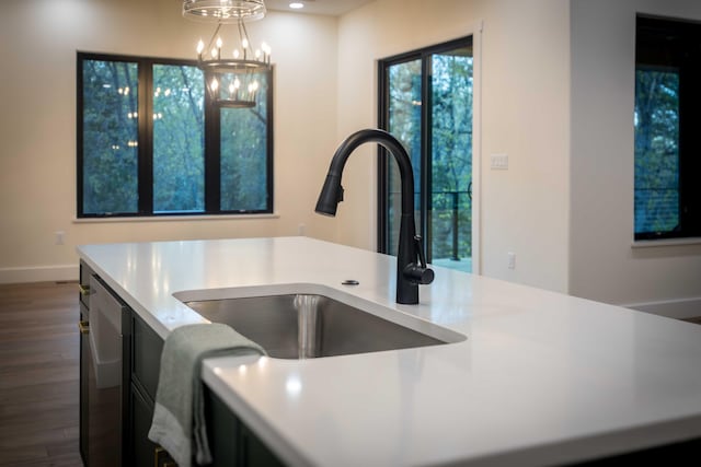 kitchen with light countertops, dark wood finished floors, a chandelier, and decorative light fixtures