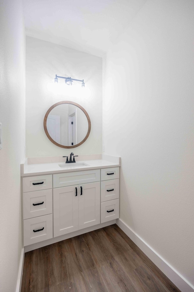 bathroom with baseboards, vanity, and wood finished floors