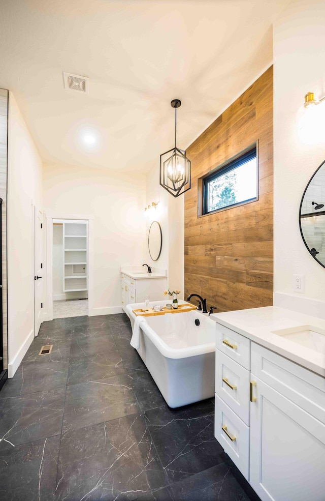 full bathroom featuring visible vents, wood walls, an accent wall, baseboards, and a freestanding bath