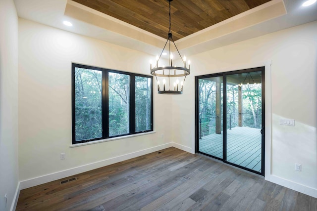 unfurnished room featuring visible vents, baseboards, a raised ceiling, wood ceiling, and a chandelier